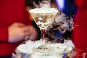 Présentation élégante d'un glace carbonique cocktail avec une épaisse fumée blanche.